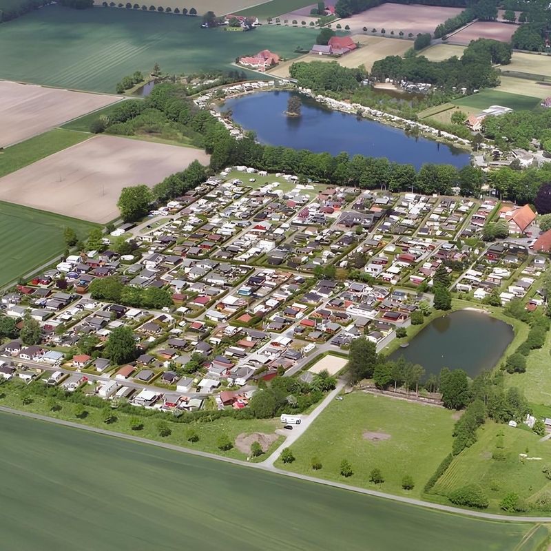 Luftaufnahme des Campingplatzes Camp zur Rotbuche Gravenbrock - Versmold mit zahlreichen Campinghäusern, umgeben von Wald und einem See.