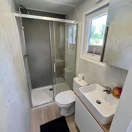Modernes Badezimmer im Chalet mit Dusche, Waschbecken und Toilette.