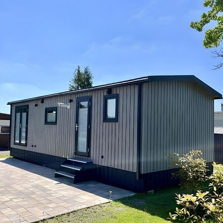 Das Moderne Heim Chalet mit Terrasse und Patio, umgeben von einer einladenden Landschaft.