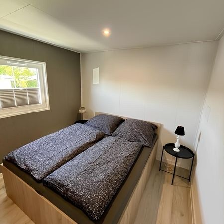 Gemütliches Schlafzimmer im modernen Heim Chalet, mit einem komfortablen Bett und einem Fenster, das den Raum natürliche beleuchtet.