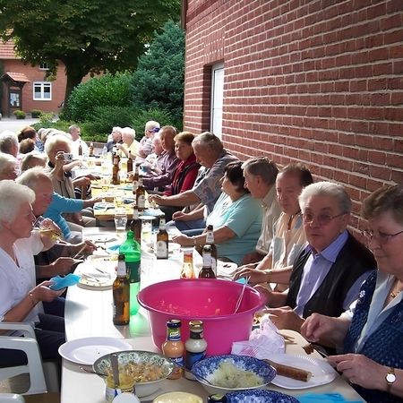 Eine Gruppe von Personen sitzt an einem Tisch und genießt gemeinsam eine Mahlzeit bei einer Veranstaltung.