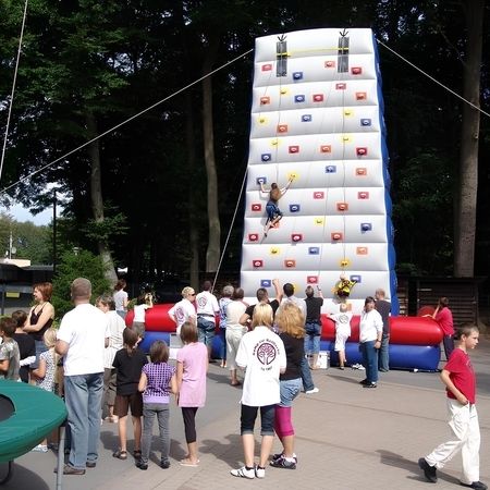 Eine Gruppe von Personen steht um eine Kletterwand und beobachtet die Kletterer.
