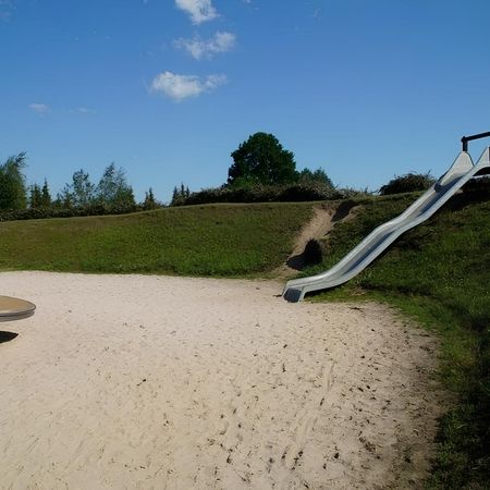 Sandspielplatz mit Rutsche und Kletterwand, idealer Spielplatz für Kinder im Freien.