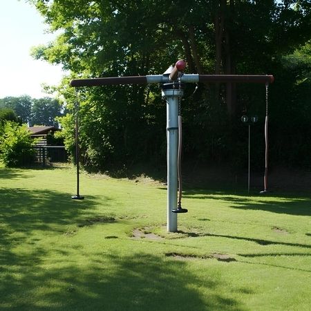 Ein Hängekarussell im Park, umgeben von üppigem Grün und schattenspendenden Bäumen, bietet Freude für Kinder.