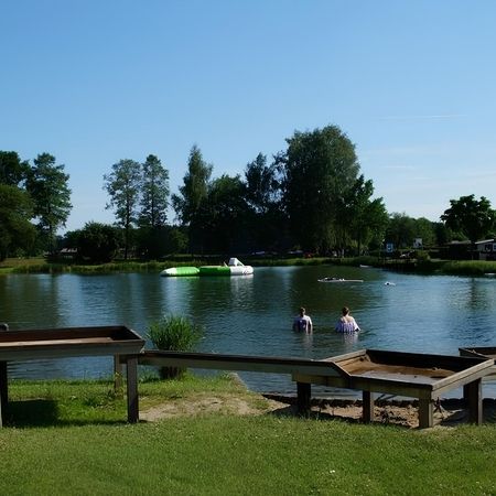 Ein See mit einem kleinen Teich, umgeben von einigen Personen, die das Wasserspiel genießen.