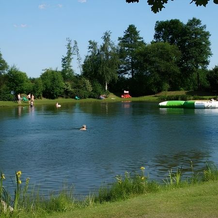 Ein ruhiger Gewässerbereich, umgeben von sanften Ufern und reflektierenden Wasserflächen.